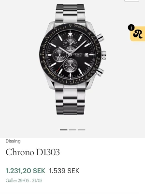 Dissing Chrono DI303 herrklocka - Stilren kronografklocka från Dissing med svart urtavla, silverfärgade detaljer och datumvisning. Boetten och länken är i blankt rostfritt stål. Klockan har tachymeter på ringen och flera små urtavlor för extra funktioner. Perfekt accessoar för dig som gillar sportig och klassisk stil.
