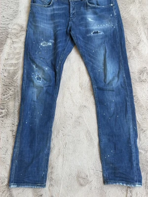 Dondup jeans - Säljer ett par Dondup jeans använda en gång, skit fett tvätt på dem och slitningar, perfekta nu till sommaren, storleken är 35 men sitter som en 33 för dem har krymt i midjan.