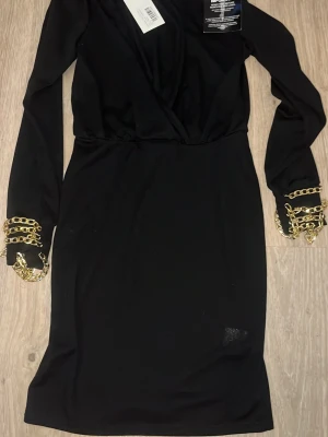 Klänning - Klänning med guldiga detaljer vid ärmarna från Nelly storlek S💗