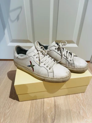 Vita skor från Axel arigato - Säljer ett par riktigt fina axel arigato skor med den klassiska fågel designen. Skorna är i gott skick, strl 42,5. Bara att skriva vid funderingar