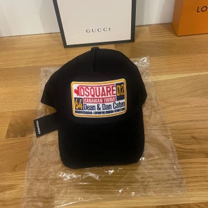 Svart keps från Dsquared2 - Helt ny och oanvänd Snygg svart keps från Dsquared2 med broderad logga framtill och texten 'BORN IN CANADA' baktill. Ny pris 1699 kr Tillverkad i 100% bomull och designad i Italien. Perfekt för en stilren look.