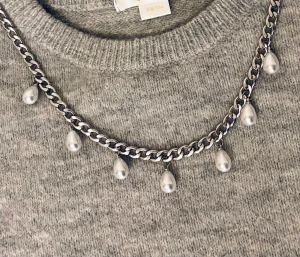 Silverfärgat halsband med pärldroppar - Snyggt halsband i silverfärgad metall med droppformade vita pärlor som hänger längs kedjan. Perfekt för att ge en elegant touch till din outfit. Kedjan är grov och ger ett trendigt intryck.