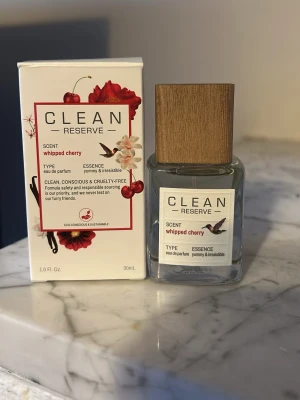 Clean Reserve Whipped Cherry parfym - En stilren parfym från Clean Reserve i doften Whipped Cherry. Flaskan är transparent med en fyrkantig form och har ett elegant lock i trä. Förpackningen är vit med röda och rosa detaljer samt körsbärsmotiv. Innehåller 30 ml eau de parfum.