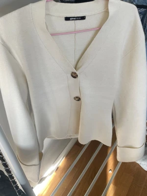 Krämvit kofta från Gina Tricot - En fin tröja/kofta från gina tricot. Den har bara används en gång och är som ny.