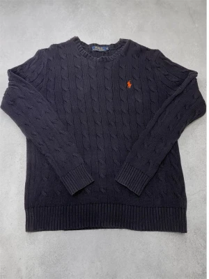 Ralph Lauren cable knit sweater navy M herr - Säljer en äkta Ralph Lauren cable knit tröja i mörkblå (navy) färg. Klassisk modell med broderad äkta logga på bröstet.   Storlek M (passar true to size, funkar även lite oversized på S). Bra skick utan större defekter. Bra skick!  Perfekt till både vardag och snyggare outfits. Väldigt eftertraktad modell som säljer snabbt.  Snabb affär prioriteras 🚀stickad tröja Raulph Lauren Cable knit