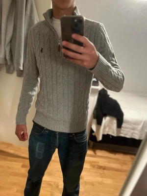 Grå kabelstickad tröja från Polo Ralph Lauren - Säljer min gråa Ralph lauren tröja i Storlek M men skulle säga att den är lite mer S. Den är i fint skick och sitter bra i storleken. 