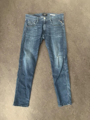 Blå slitna jeans från Replay - Säljer min replay jeans då dom har blivit försmå för mig. Ett par replay jeans som är väldigt bekväma och sitter riktigt bra i passformen    32L 32W