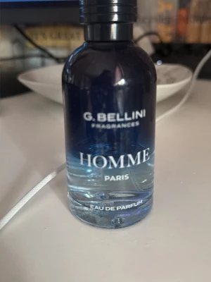G. Bellini Homme Eau de Parfum - En stilren parfymflaska från G. Bellini med doften Homme Paris. Flaskan är gjord av glas och har en snygg blå färg som tonar ut mot genomskinligt nedtill. Perfekt för dig som gillar fräscha och maskulina dofter.