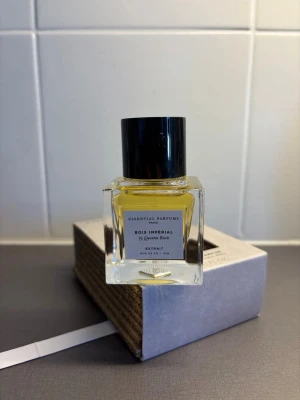 Bois Impérial Extrait från Essential Parfums - NY. Bois Impérial Extrait från Essential Parfums är en exklusiv parfym i en stilren, fyrkantig glasflaska med svart lock. Doften är skapad av Quentin Bisch och har en elegant etikett framtill. Otroligt långvarig doft. 