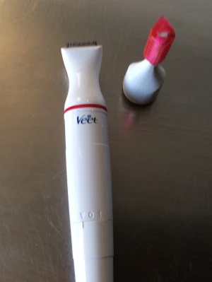 Veet elektrisk trimmer vit/röd - Elektrisk trimmer från Veet i vit plast med röda detaljer. Kommer med ett utbytbart huvud och ett rött skydd. Perfekt för ansikte och känsliga områden. Smidig och lätt att använda för precisionsrakning.