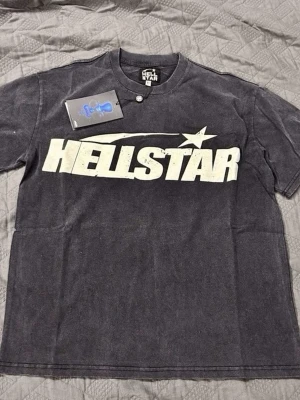 Svart Hellstar t-shirt med tryck - Cool svart t-shirt från Hellstar med stort vitt tryck över bröstet. Klassisk passform och rund halsringning. Perfekt för dig som gillar streetwear och vill sticka ut med en statement-tee.