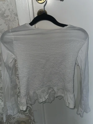  vit långärmad topp  - Säljer en vit långärmad topp  har ba använd en gång den blir kort för mig 