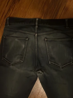 Bläck jeans  - Säljer ett par mörkblå slim jeans med slitningar och snygga detaljer. Notera ett litet hål i skrevet, därav priset!