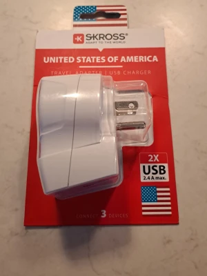 SKROSS reseadapter USB USA - Praktisk vit reseadapter från SKROSS för USA med två USB-portar (2.4A max). Perfekt för att ladda flera enheter samtidigt när du är utomlands. Kompakt design i plast och enkel att ta med i väskan. Passar amerikanska eluttag.