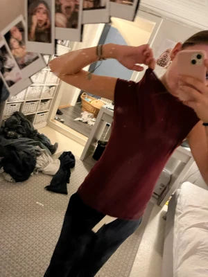 Vinröd ärmlös topp - Säljer en enkel och stilren vinröd topp med hög hals och ärmlös design. Toppen har en tight passform och är perfekt att matcha med både jeans och kjol. Materialet känns mjukt och stretchigt, troligen i bomull eller polyester.