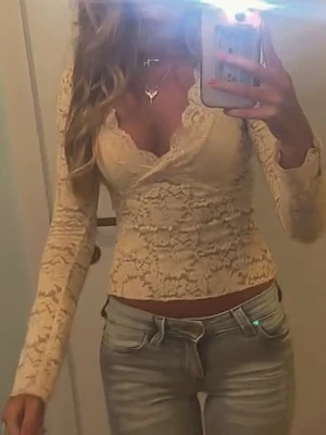 Gul spetsblus med v-ringning - Säljer en gul långärmad blus i spets som är v ringad. Toppen är figurnära och har transparenta spetsdetaljer över hela plagget. Perfekt för dig som gillar romantisk och feminin stil. Använd 1 gång