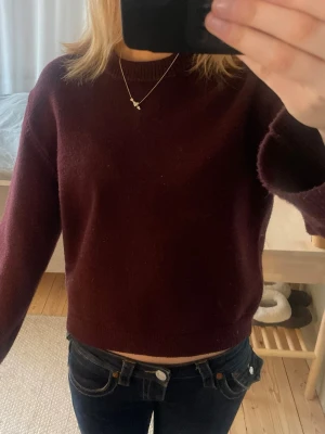 Mörkröd croppad stickad tröja - Säljer en enkel och stilren mörkröd stickad. Tröjan har långa ärmar och är perfekt att matcha med jeans. Väldigt fin och inga defekter❤️