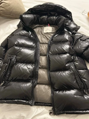 Svart glansig dunjacka Moncler - Säljer en svart glansig dunjacka från Moncler. Helt ny inga defekter om vi vill ha fler bilder tveka inte. Den är M. Pris går alltid att diskutera 