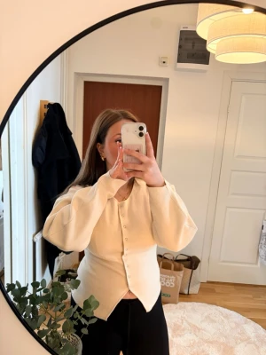 Vit cardigan - Snygg krämvit tröja. Tröjan har lång ärm och en något figurnära passform. Använd ett fåtal ggr