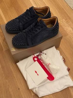 Christian Louboutin Vieira 2 sneakers strl 43 - Säljer mina använda Christian Louboutin Vieira 2 sneakers i strl 43. Kommer med låda, dustbags, extra snören, extra nitar och skohorn. Skicket ser ni på bilderna - använda så märken finns på både mockan (riktig mocka) och nitarna och där de viker sig när man går (se sista bilden). Dock ser de ganska fräscha ut fortfarande, och redo för att användas tills de slits helt dvs! Säljs därför i befintligt skick. Postar helst om det köps via plick. 