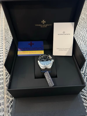 Vacheron Constanti klocka silver/svart - Snygg klocka från Vacheron Constanti med svart urtavla, datumfönster och silverfärgat boett. Armbandet är svart med struktur och klockan levereras i originalbox med certifikat och garanti. Perfekt för dig som gillar exklusiva accessoarer. Best quality with nightlight function🎆. Fast shipping. 
