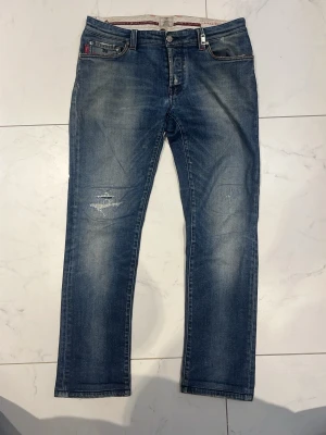  Tramarossa  jeans - Säljer ett par skit snygga Tramaross jeans från Italien storlek 32/32.Snyggt design på insidan och utsidan av jeansen med massa detaljer och feta slitningar på båda knäna 