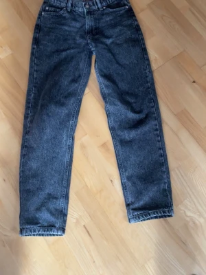 Mörkblå raka jeans i vintage-stil - Säljer ett par mörkblå jeans med rak passform och hög midja. Jeansen har klassisk femficksdesign och är gjorda i kraftigt denimtyg. Perfekta för dig som gillar en tidlös och avslappnad look. Ny pris 500kr