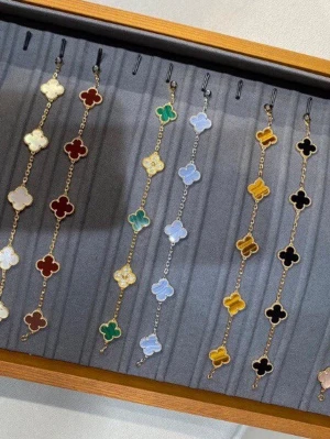 Färgglada armband med fyrklöver - Snygga armband med fyrklöverformade hängen i olika färger som röd, grön, blå, svart, gul och pärlemor. Armbanden har guldfärgade länkar och varje hänge har en glansig yta som ger en exklusiv känsla. Perfekt accessoar för att lyfta din stil.