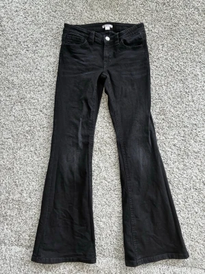 Gina Tricot - Svarta bootcut jeans - Säljer ett par svarta bootcut jeans från Gina Tricot. Jeansen har klassisk femficksmodell, låg midja och utsvängda ben. 