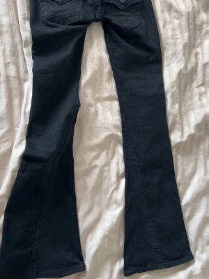 Svarta utsvängda jeans - Säljer helt nya svarta true religion joey jeans med utsvängda ben. Jeansen har en snygg passform med låg midja. (Ej prislapp kvar) kan abslout tänka mig sänka priset vid snabbt köp💗om ni har några frågor är det bara att kontakta mig!☺️💕