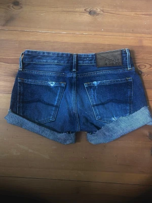 Y2k jeansshorts - Lågmidjade jeansshorts med små rosa detaljer och vissa slitningar i tyget vilket ger en cool 2000 känsla av dem. I princip oanvända, så väldigt fina. Perfekt nu till sommaren! Strl XS  Skriv om du har frågor!!🥰 svarar snabbt