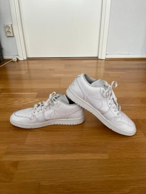 Air Jordan 1 Low Triple White – Storlek 42 - Säljer ett par Air Jordan 1 Low Triple White i storlek 42. Skorna är i bra skick med lite tecken på användning. Den helvita färgsättningen är stilren, lätt att matcha och passar både till vardags och mer uppklädda tillfällen.