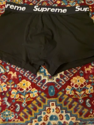 Svarta Supreme kalsonger  - Säljer ett par svarta kalsonger från Supreme i storlek S/m. De har en bred resår med Supreme-loggan i vitt och är tillverkade av 95% bomull och 5% spandex för skön stretch. Klassisk boxermodell som sitter snyggt och bekvämt. Storleken är L men passar ser ut att passa S/m! Helt nya!