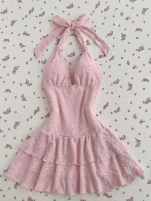 Köpte den för 280kr men säljer billigare då jag inte vill ha den i garderoben längre 😂 har använt den en gång men färgen passade inte mig! - Supersöt rosa klänning i spets med volangkjol och knyt i nacken. Klänningen har en figurnära passform upptill och är ärmlös med halterneck. Perfekt för sommarens alla tillfällen och ger en romantisk vibe.