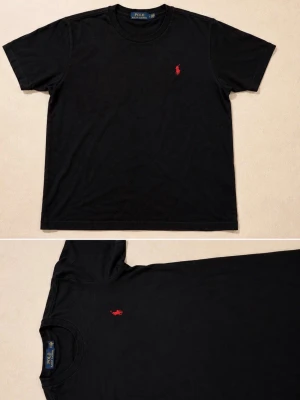 Svart t-shirt från Polo Ralph Lauren - Klassisk svart t-shirt från Polo Ralph Lauren med röd broderad logga på bröstet. T-shirten har rund halsringning och korta ärmar. Tillverkad i mjuk bomull för en skön känsla och enkel stil.