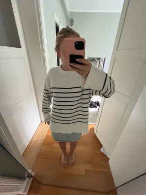 Vit stickad tröja med ränder - Säljer en oversized vit stickad tröja med horisontella ränder. Tröjan har rund halsringning, långa ärmar och breda muddar. Perfekt för en avslappnad och trendig look.