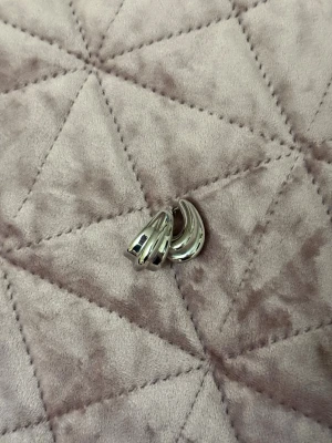 Chunky silverfärgade hoops - Säljer ett par chunky örhängen i silverfärgad metall med en cool, rundad design. De har en stilren och modern look som passar perfekt till alla outfits. Örhängena är i en klassisk hoop-modell och känns både trendiga och tidlösa.