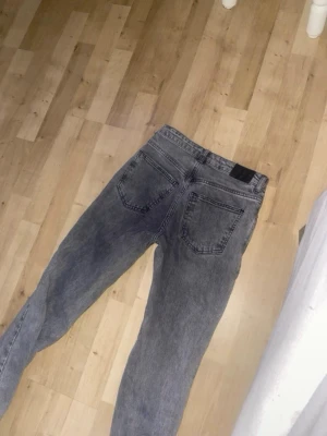 Grå  jeans från Perfect Jeans - Säljer ett par grå mom jeans från Perfect Jeans. De har hög midja, raka ben och klassiska bakfickor. Jeansen är tillverkade i ett mjukt denimtyg som ger en avslappnad och trendig look. Perfekta för dig som gillar en vintage-inspirerad stil.