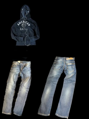Helt nya* Nudie Jeans - Säljer ett par klassiska blå jeans från Nudie Jeans med snyggt slitna detaljer och raka ben. Jeansen har fem fickor, orange sömmar och är gjorda i mjuk bomullsdenim. Perfekta för en avslappnad och trendig look. Sitter skinny på mig. Säljes då dom var för små. Först till kvarn.
