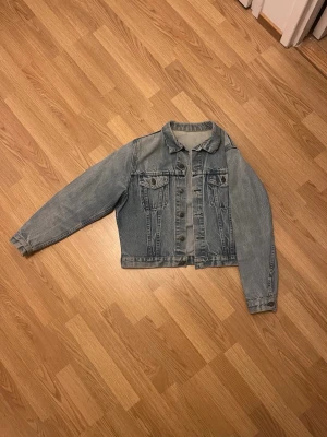 jeansjacka - Snygg ljusblå jeansjacka med raka ärmar och två bröstfickor med lock och knapp. Jackan har en klassisk krage och knäppning framtill. Perfekt oversized look och funkar till det mesta.