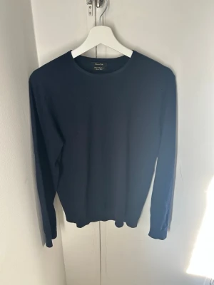 Mörkblå tröja från Massimo Dutti - Klassisk mörkblå tröja från Massimo Dutti med rund halsringning och långa ärmar. Enkel och stilren design som passar perfekt till jeans eller chinos. Tillverkad i mjukt material för en bekväm känsla.