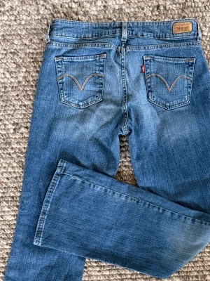 Lågmidjade bootcut från Levis - Jättesnygga klassiska Levi's jeans. Lågmidjade (inte superlågmidjade) och bootcut - precis som man vill ha det. Jeansen är vintage och är köpta i USA. Sitter otroligt skönt på och skapar snygga former. De är använda men på grund av kvaliteten så är de i princip i nyskick. Skulle säga att man kan översätta storleken som W32/L32 och passar mig som är 172 cm. Hör av dig för mer information eller fler bilder. 