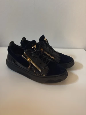 Svarta Giuseppe Zanotti - Snygga svarta skor från Giuseppe Zanotti med guldfärgade dragkedjor och logga på plösen. Skick 8/10, hör av er i dm för mer frågor! 