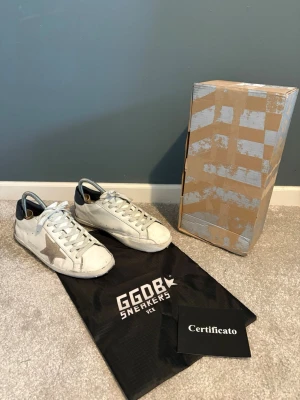 Golden Goose Superstar vita sneakers - Säljer mina golden goose skor stl 42. Skorna är i bra skick men har som de flesta golden goose skor lite slitningar på sulan. Orginalbox och dustbag medföljer. Hör av dig vid frågor och funderingar!