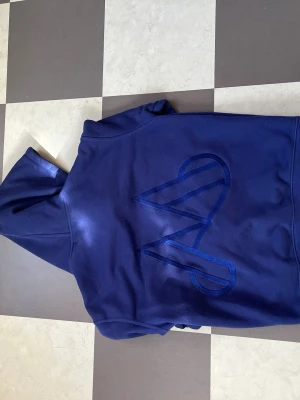 Maggiore hoodie  - Snygg blå hoodie från Maggiore med stor M-detalj på ryggen i samma färg. Klassisk passform med huva och känguruficka framtill. Tillverkad i mjukt material som känns skönt mot huden. Perfekt för dig som gillar streetwear och vill sticka ut lite extra.