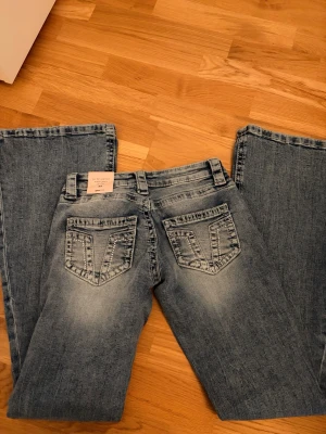 Lågmidjade jeans från Gina Tricot XS - Säljer ett par blå lågmidjade jeans från Gina Tricot i modellen 'for real low waist'. Jeansen har bootcut ben, klassisk femficksdesign framtill och på bakfickorna. Perfekta för dig som gillar en avslappnad och trendig look.