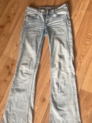 Ljusblå bootcut jeans CHEAP MONDAY - Säljer ett par ljusblå bootcut jeans från Cheap Monday med klassisk femficksmodell och coolt grönt märke bak. Jeansen är tillverkade i mjukt denimtyg med stretch. Perfekta för dig som gillar retrovibbar och relaxed stil.