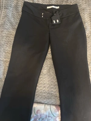 Svarta low waist bootcut kostymbyxor  - Snygga low waist svarta kostymbyxor från lager 157 med bootcut-modell och bred linning. Perfekta för en trendig och bekväm stil. Mjukt och stretchigt material som sitter skönt hela dagen. 