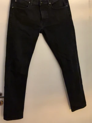 Svarta skinny jeans från Lee - Säljer ett par svarta skinny jeans med klassisk femficksdesign och smal passform. Jeansen har hög midja och raka ben, perfekta till en avslappnad eller trendig look. Materialet är stretchigt denim för extra komfort.