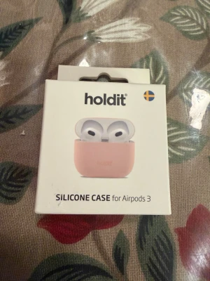 Holdit silikonfodral AirPods 3 - Snyggt och tunt silikonfodral till AirPods 3 från Holdit. Fodralet är ljusrosa, tillverkat i mjukt silikon och skyddar mot stötar. Super slim design på 0,8 mm och vegancertifierat material. Perfekt för dig som vill ha ett stilrent skydd till dina hörlurar.